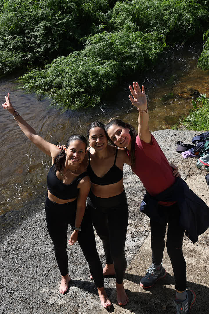 Tres peregrinas celebrando en un río al terminar la etapa
